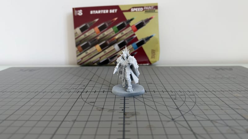 The primed Reclusian on a cutting mat, with a Speedpaint Marker starter set behind it.