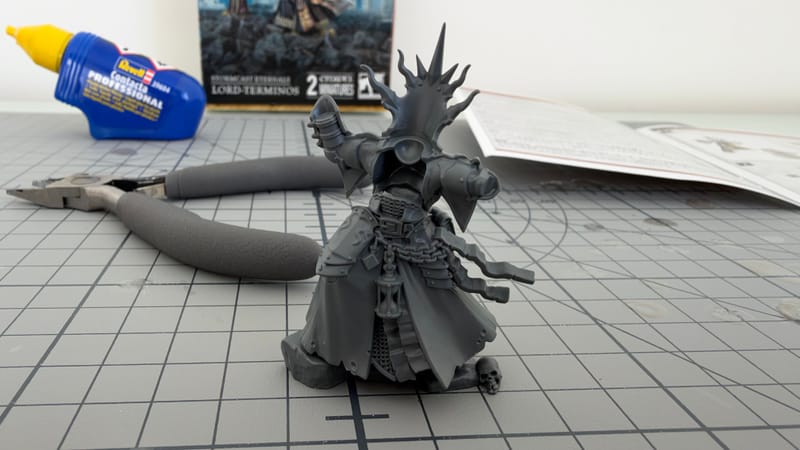 Lord-Terminos, fully built and unpainted, on a cutting mat, with clippers, a tube of plastic glue and its box behind it.